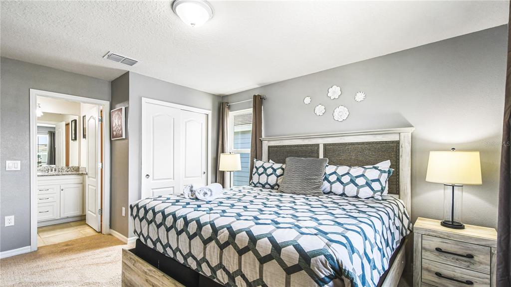 7219 Oakmoss Loop Davenport, FL 33837 - Photo 42 of 54 a bedroom with a bed and a lamp