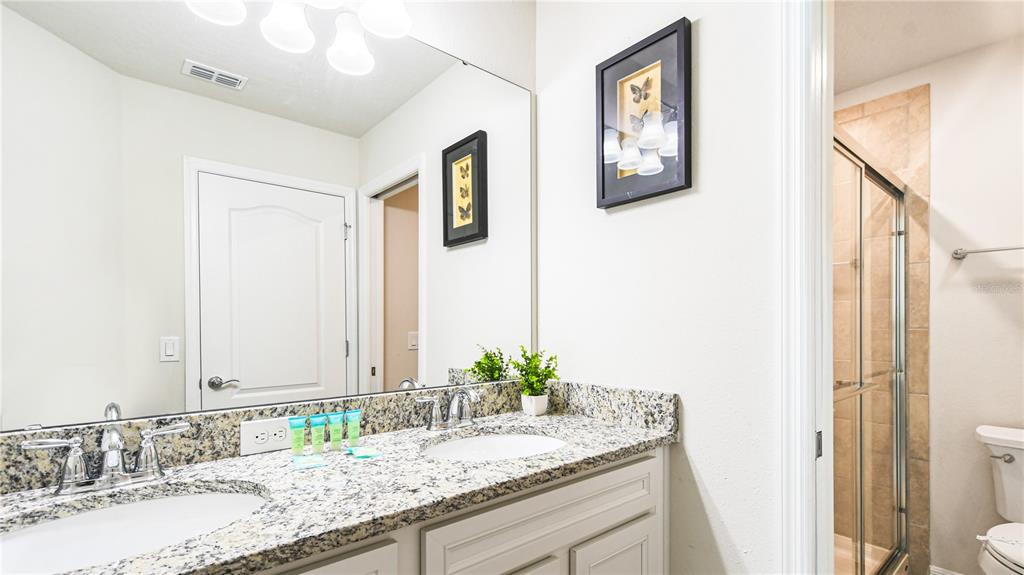 7219 Oakmoss Loop Davenport, FL 33837 - Photo 43 of 54 a bathroom with a granite countertop sink and a mirror