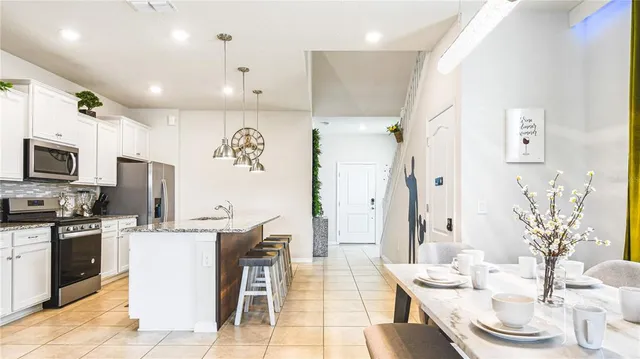 a large kitchen with stainless steel appliances kitchen island granite countertop a sink and cabinets