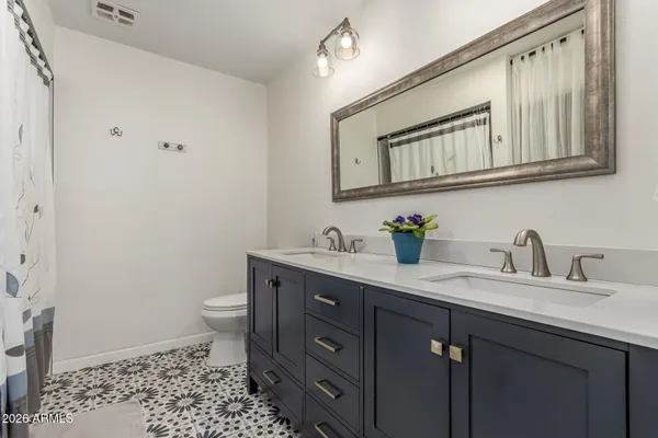 a bathroom with a sink a toilet and a mirror