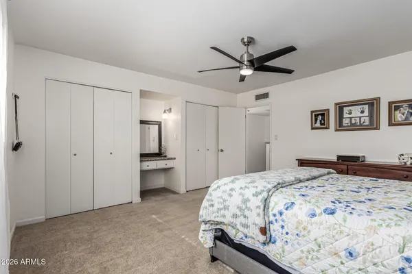 a bedroom with a large bed and a ceiling fan