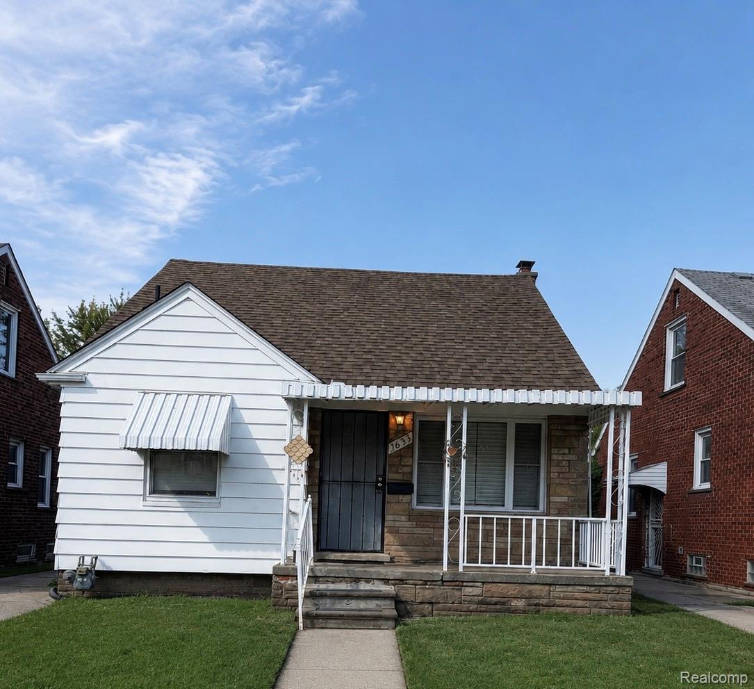 Front exterior with white siding, stone façade, and a pitched roof
