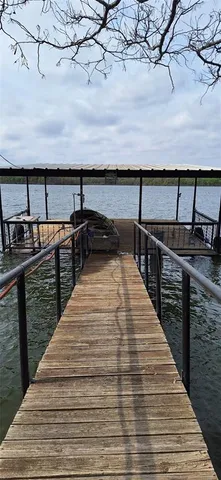 a front view of a house with large trees and houses