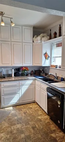 a kitchen with stainless steel appliances granite countertop a sink a stove and white cabinets