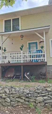 a front view of a house with garden and sitting area
