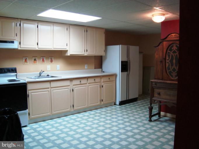 8166 N Road Severn, MD 21144 - Photo 5 of 25 a kitchen with a sink a refrigerator and cabinets