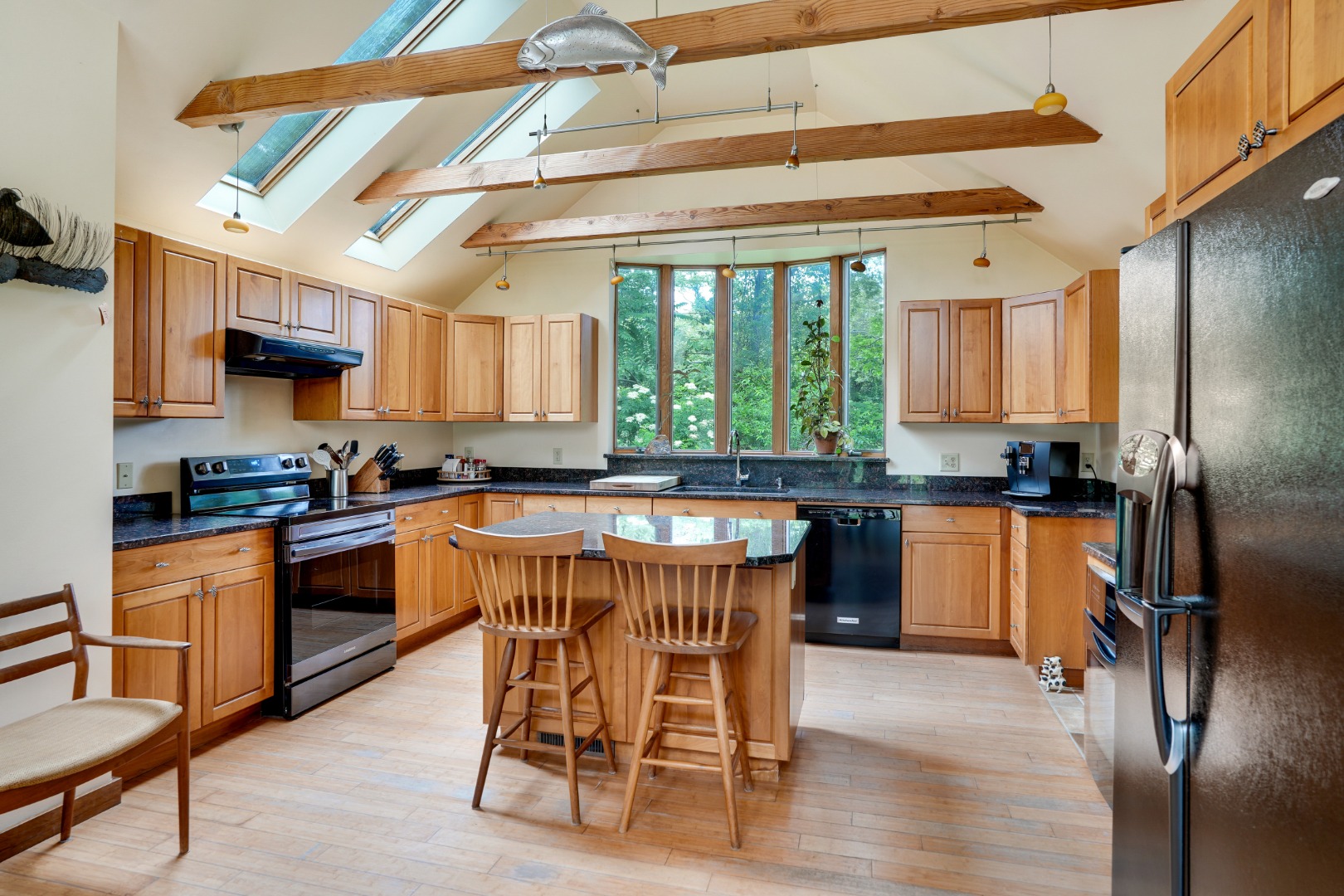 174 Middle Road Chilmark, MA 02535 - Photo 7 of 40 a kitchen with stainless steel appliances granite countertop a stove top oven a sink a refrigerator with a dining table and chairs