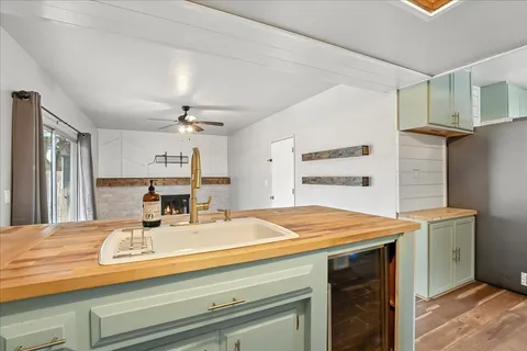 a room with kitchen island a sink and refrigerator