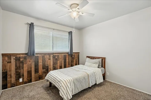 a bedroom with a large bed and a chandelier