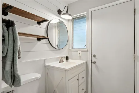 a bathroom with a sink mirror vanity and toilet