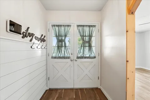 a view of a livingroom with wooden floor and a flat screen tv