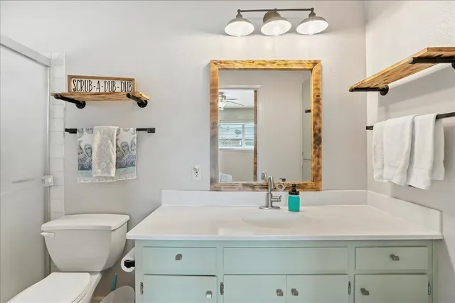 a bathroom with a sink mirror vanity and toilet