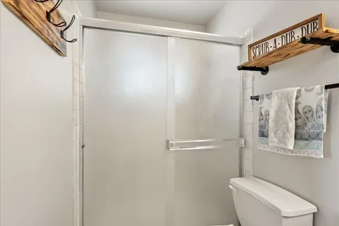 a bathroom with a shower a toilet and a shower