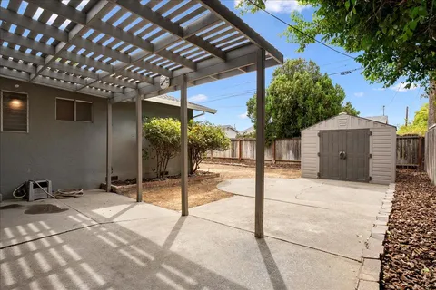 a view of a house with backyard and sitting area