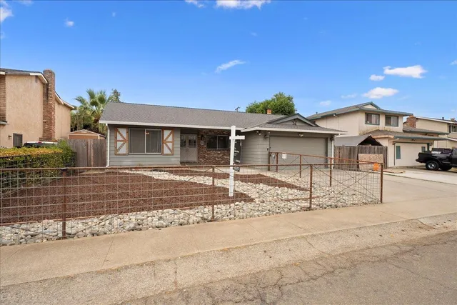 a front view of a house with a garden and yard