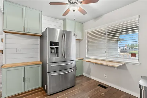 a kitchen with stainless steel appliances a refrigerator a sink and white cabinets