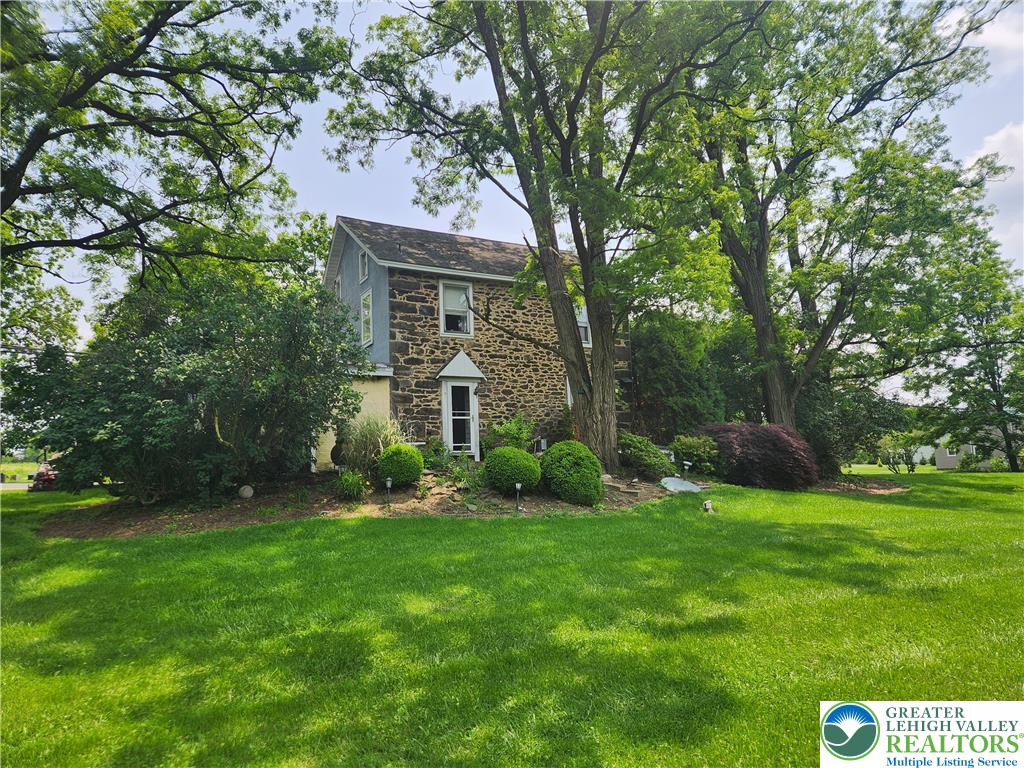 717 Point Phillips Road Bath, PA 18014 - Photo 6 of 34 a view of a brick house with a big yard and large trees