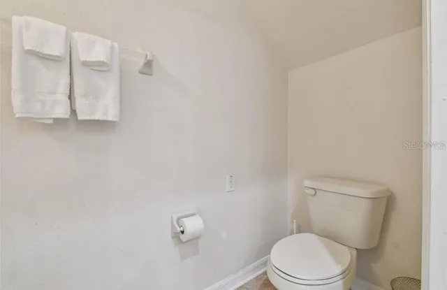 a white toilet sitting next to a shower
