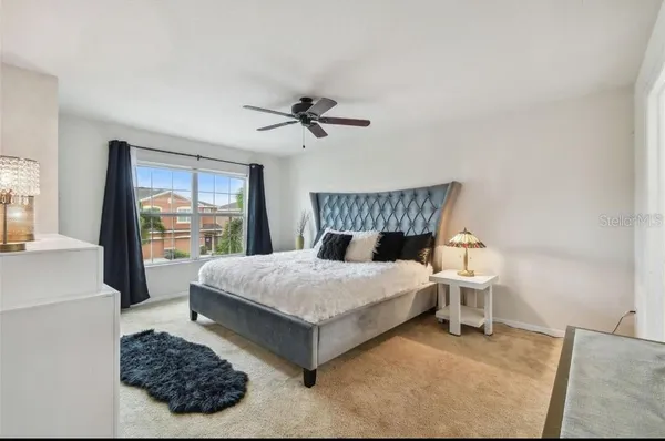 a bedroom with a bed chandelier and a window