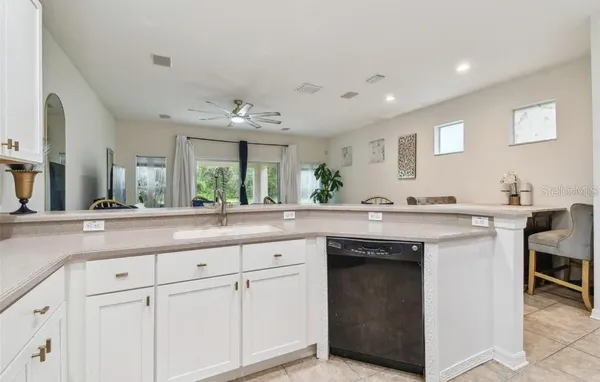 a view with cabinets a sink and chairs in a room