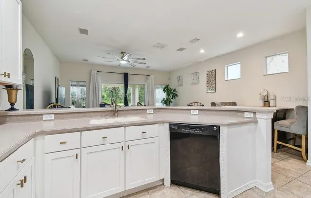 a view with cabinets a sink and chairs in a room