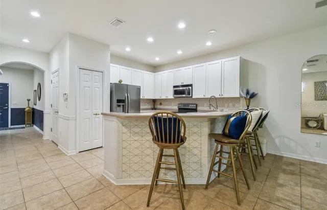 a kitchen with stainless steel appliances kitchen island granite countertop a refrigerator and a stove top oven