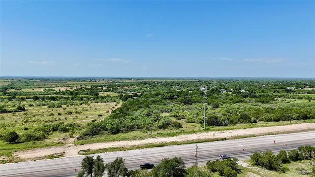 an aerial view of a houses with yard and green space