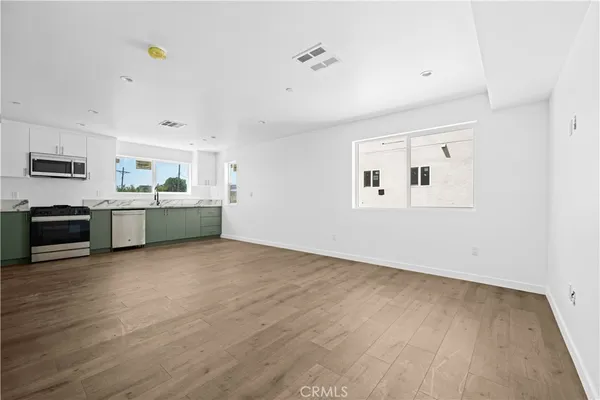 a view of a kitchen with a sink stove cabinets and empty room