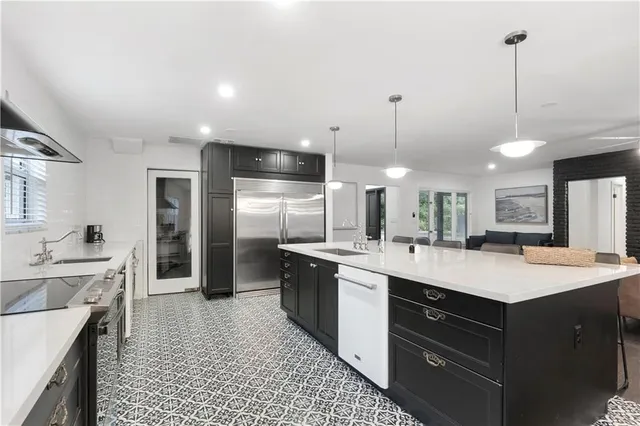 a kitchen with a sink a counter top space stainless steel appliances and cabinets