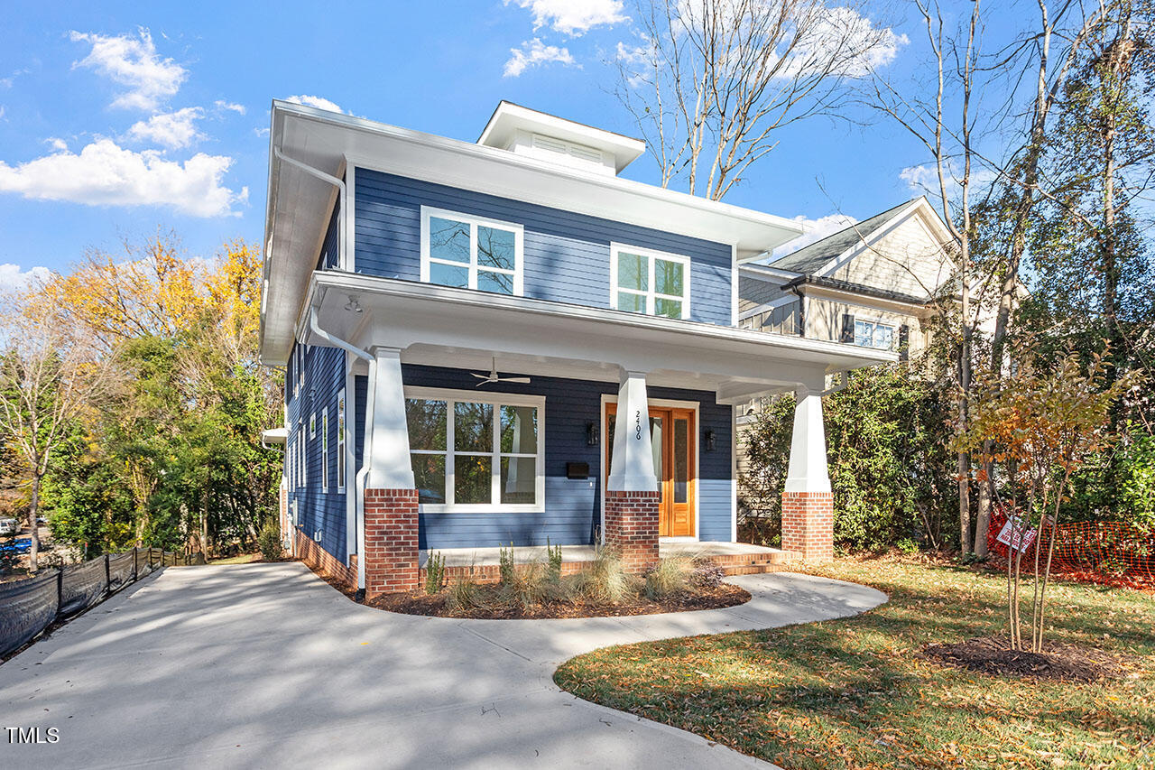 2406 Everett Avenue Raleigh, NC 27607 - Photo 2 of 40 a view of a white house with large windows and a small yard