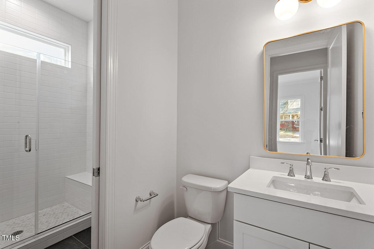 2406 Everett Avenue Raleigh, NC 27607 - Photo 27 of 40 a bathroom with a toilet sink vanity and mirror