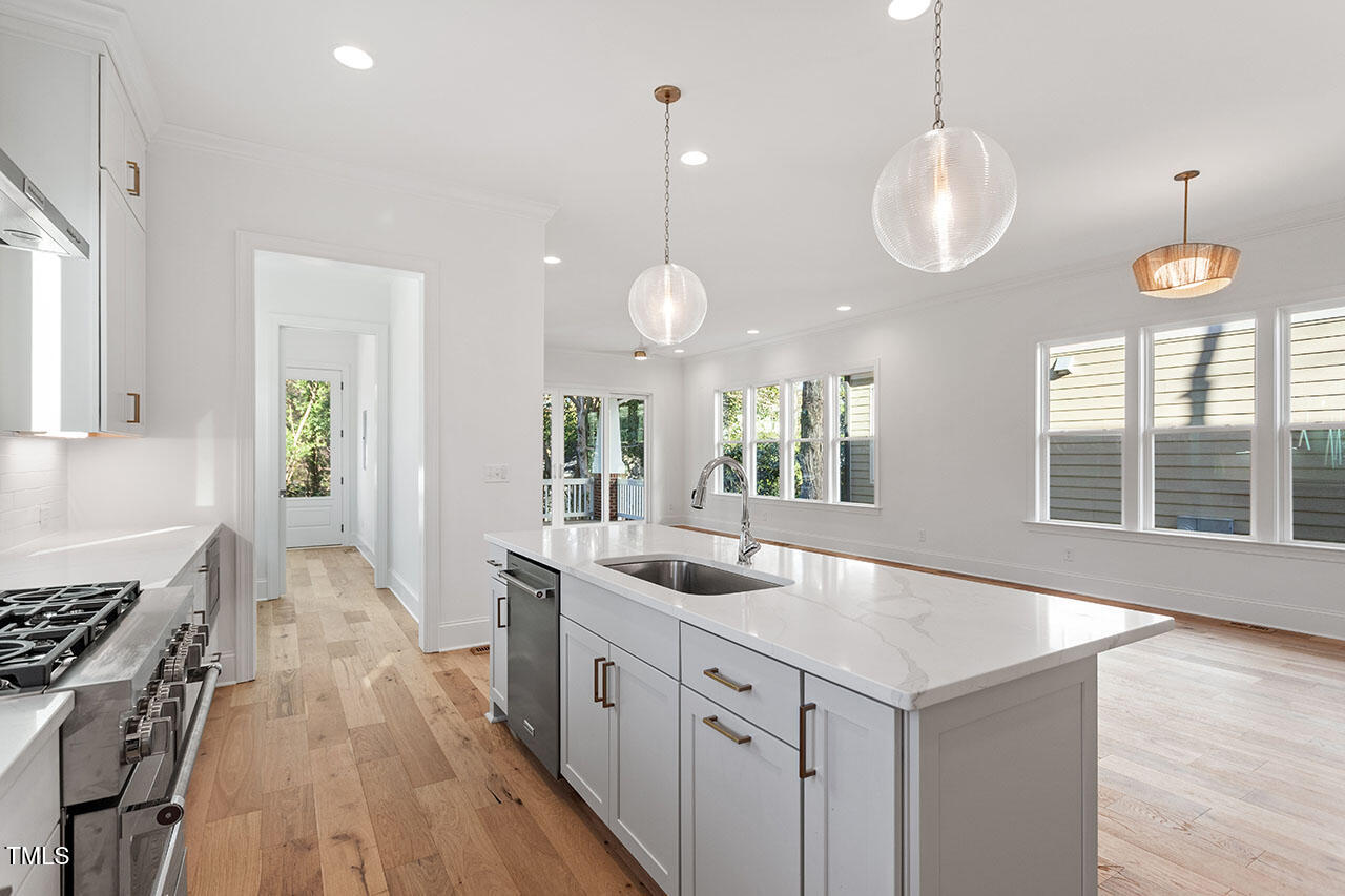 2406 Everett Avenue Raleigh, NC 27607 - Photo 32 of 40 a kitchen with counter top space a sink and wooden floor