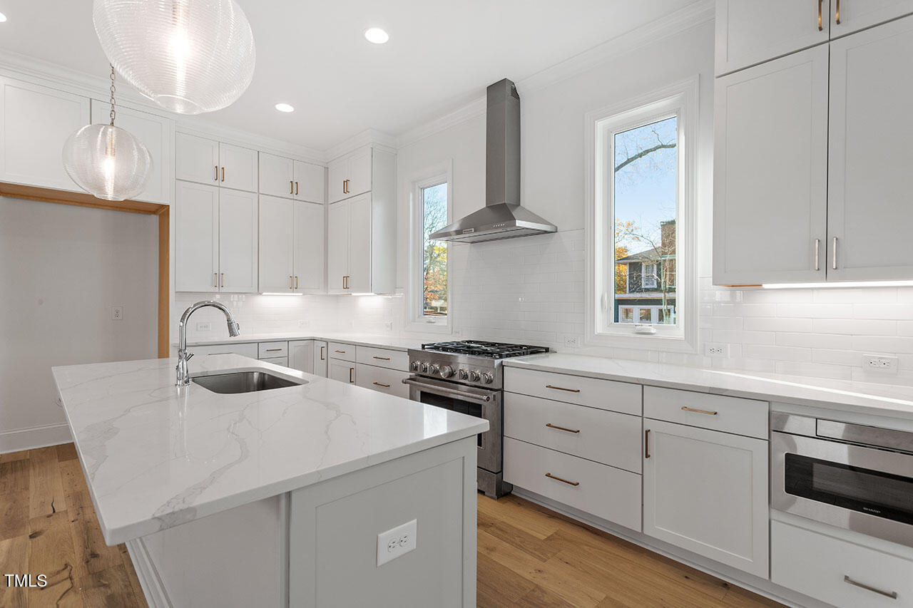 2406 Everett Avenue Raleigh, NC 27607 - Photo 33 of 40 a kitchen with white cabinets appliances and sink