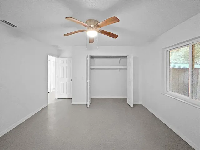an empty room with closet and windows