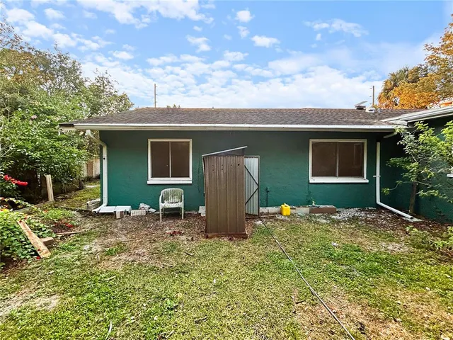 a backyard of a house with table and chairs