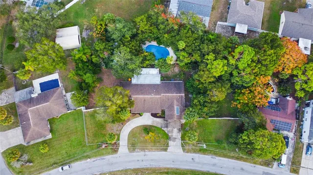 an aerial view of a house with a garden and trees