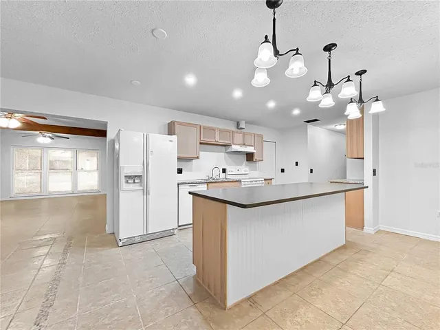 a view of a kitchen with a sink and chandelier