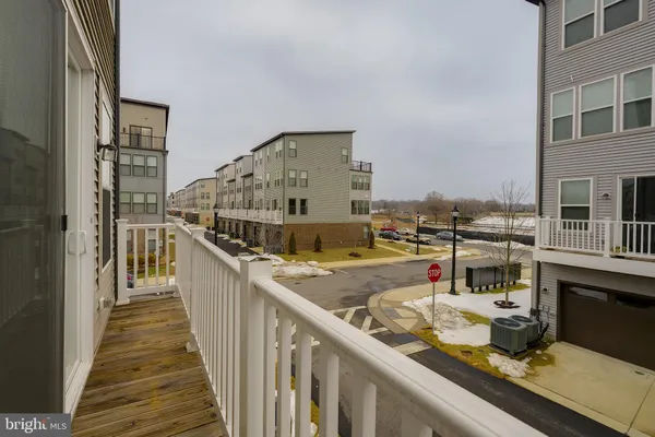 a balcony with view of living room and wooden floor