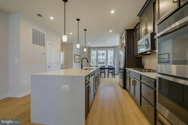 a kitchen with stainless steel appliances granite countertop lots of counter top space a sink and a large window