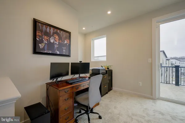 a view of a workspace with furniture and a window