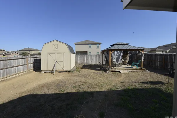 a backyard of a house with table and chairs