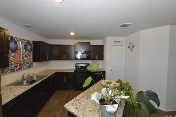 a kitchen with stainless steel appliances granite countertop a sink stove and cabinets