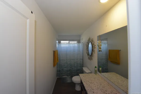 a bathroom with a granite countertop sink toilet and shower