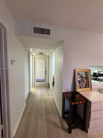 a bedroom with a bed wooden floor and a television