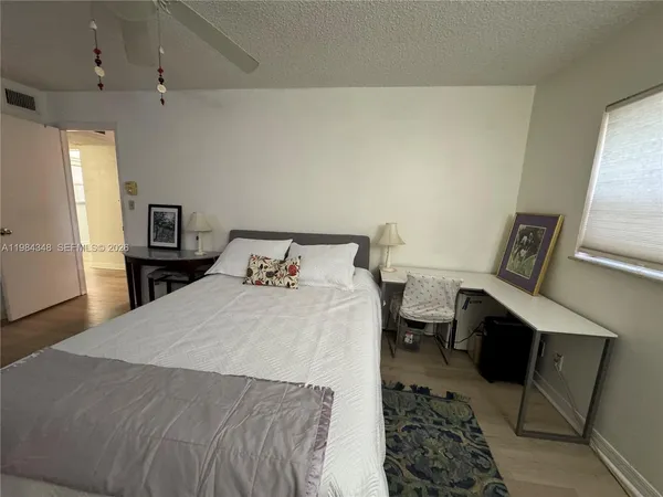 a spacious bedroom with a bed and a chandelier