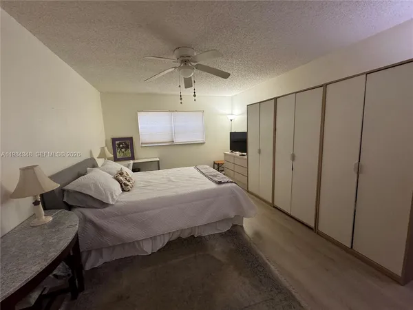 a bedroom with a bed and a flat tv screen on dresser