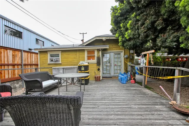 a view of a roof deck with table and chairs couches with wooden floor and fence