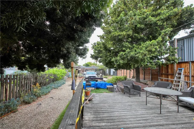 a view of a patio with table and chairs potted plants with wooden floor and fence