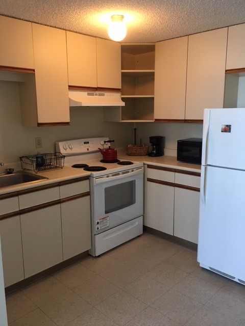 84 Pukihae Street, Unit 804 Hilo, HI 96720 - Photo 2 of 16 a kitchen with a white cabinets and white appliances