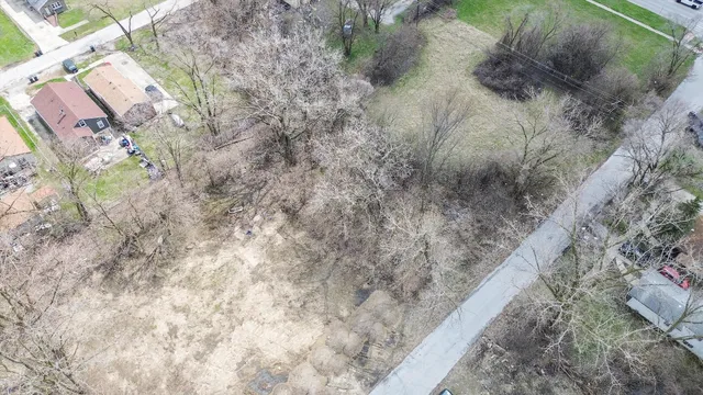 a view of a dry yard with wooden fence